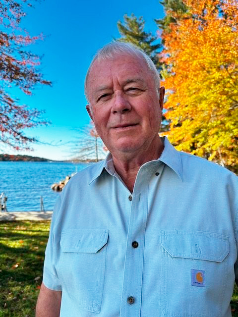 Gary Tasker, founder of Tasker Landscaping, beside a lake in autumn