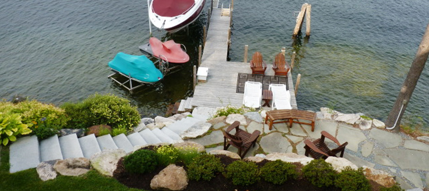 Curved stone steps and a lakeside patio leading to the lake