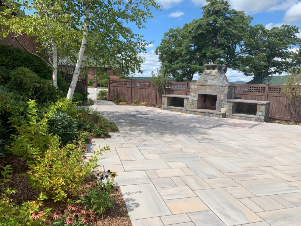 Tasker’s stone outdoor fireplace, expansive paver patio and garden borders